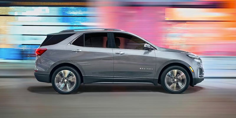 a gray 2024 chevy equinox from the left side with a colorful blurred background