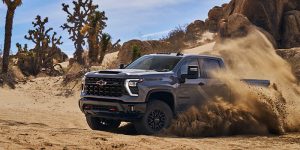 a gray 2024 Chevy Silverado 2500 HD driving on a desert sand road kicking it up | Vancouver, WA