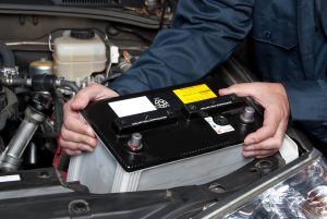 A car mechanic installing a new car battery into a car | Vancouver, WA