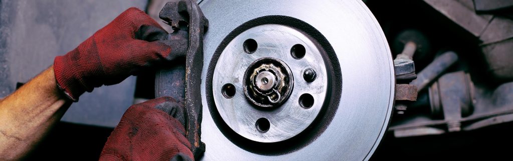 Mechanic working on a car's disc brake assembly