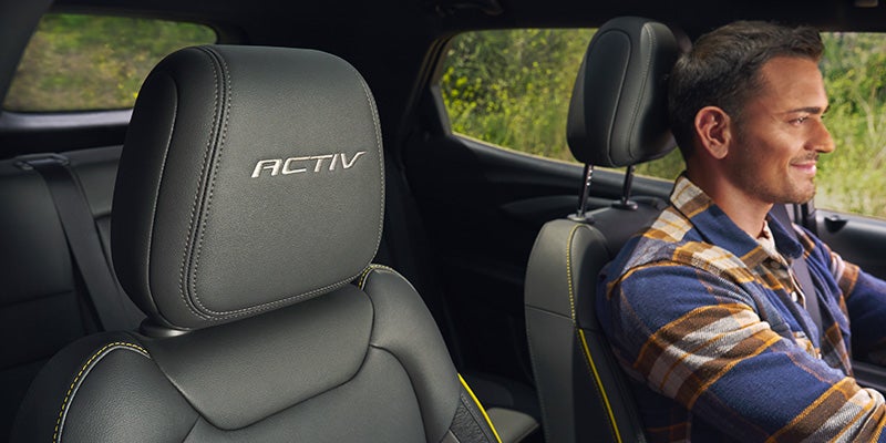 close up of head rest front seat of the 2024 chevy trailblazer with a man in the drivers seat